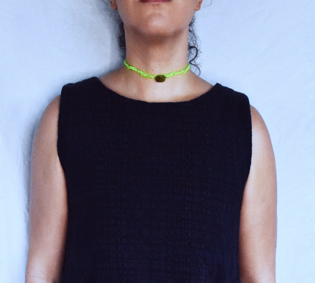 Neon green crochet lariat necklace worn closely around the back of the neck showing adjustable wrap construction