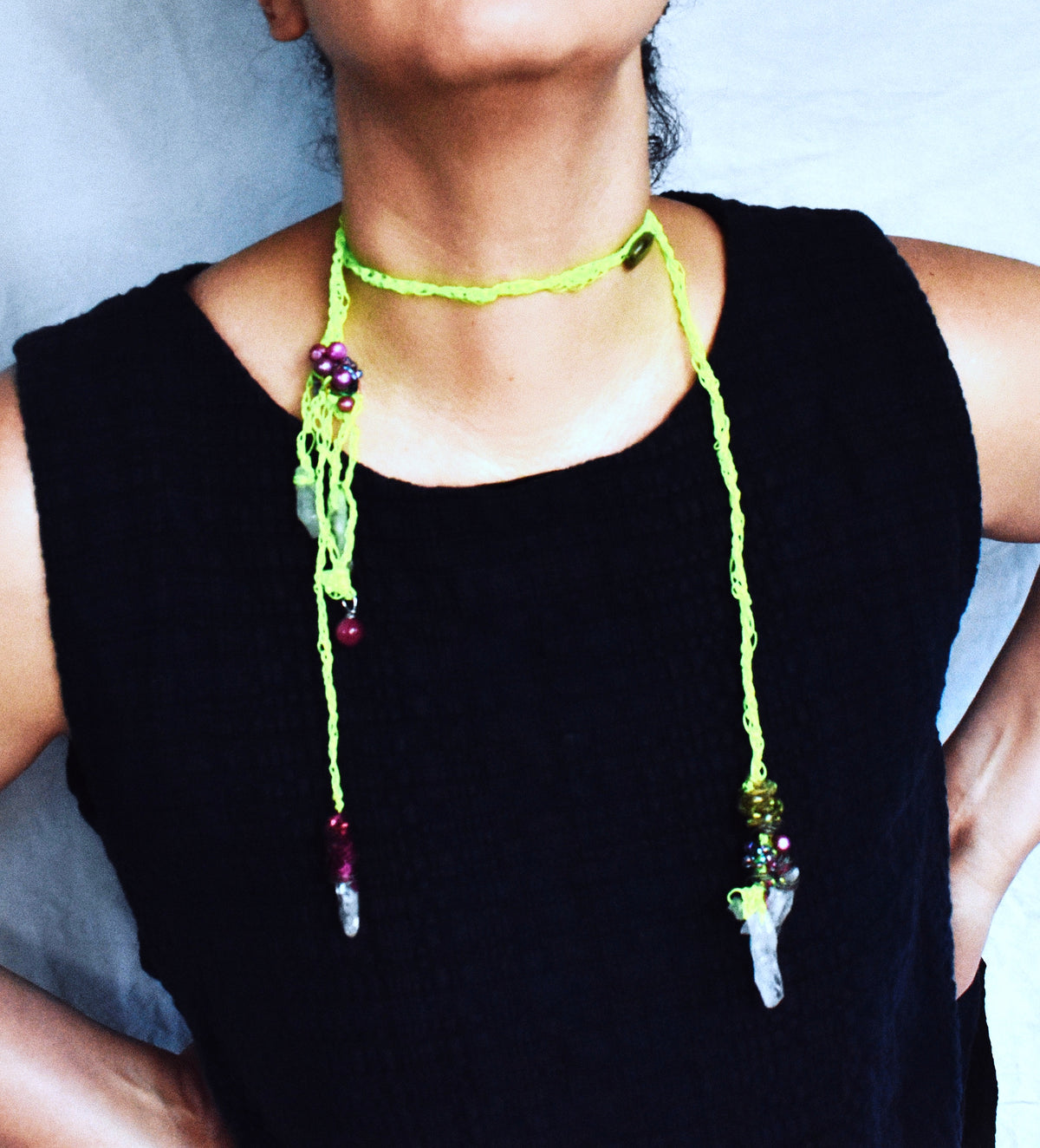 Handmade gemstone wrap lariat with quartz shards and fuchsia pearls worn asymmetrically in neon green crochet cord