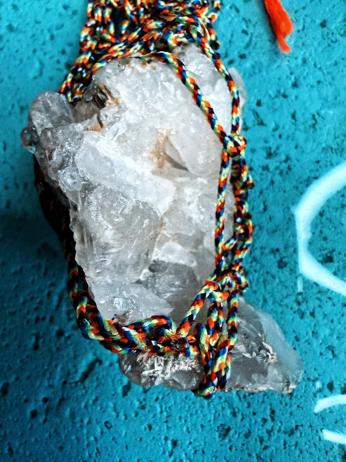 Close-up of fluorite egg and raw Tibetan quartz wrapped in neon and multicolored cord
